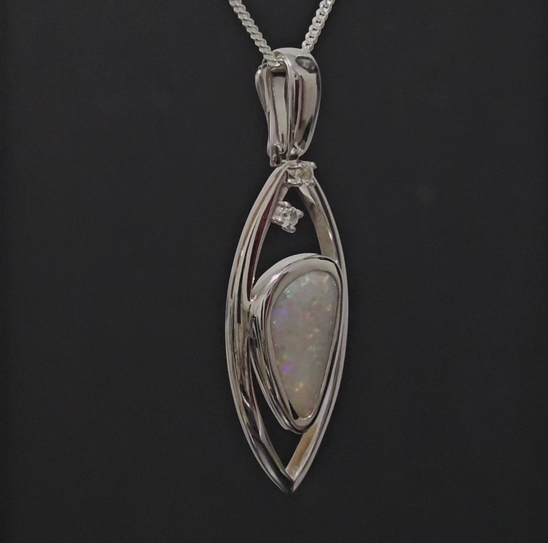 Large silver pendant adorned with light opal spinning to give 360 degree view.