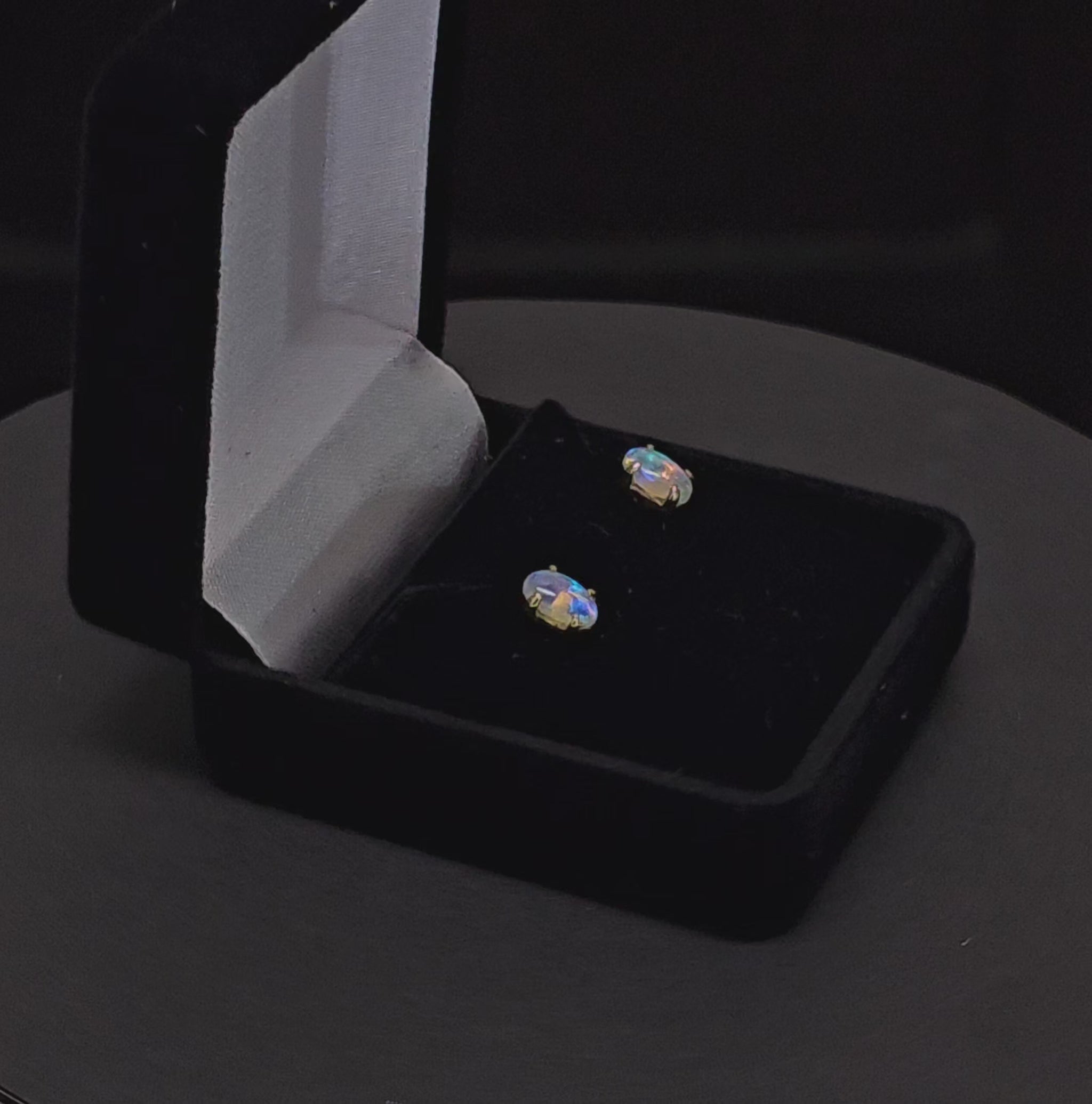 Light opal claw set in 18K yellow gold stud earrings.