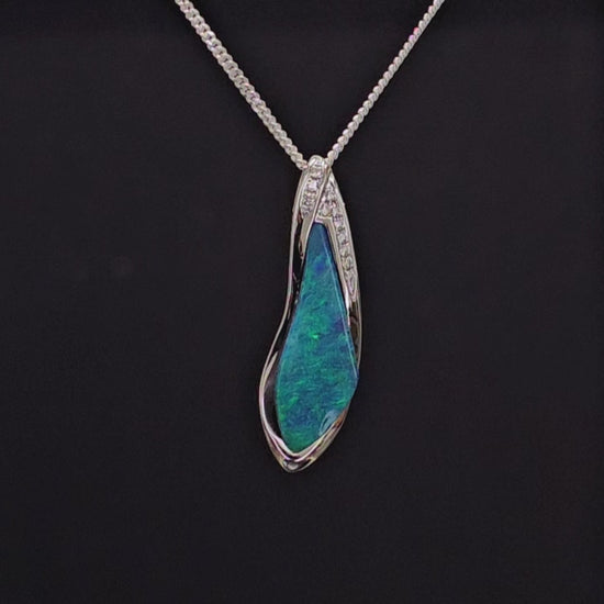 A resplendent unparalled white gold necklace adorned with several small diamonds and a vibrant green opal.