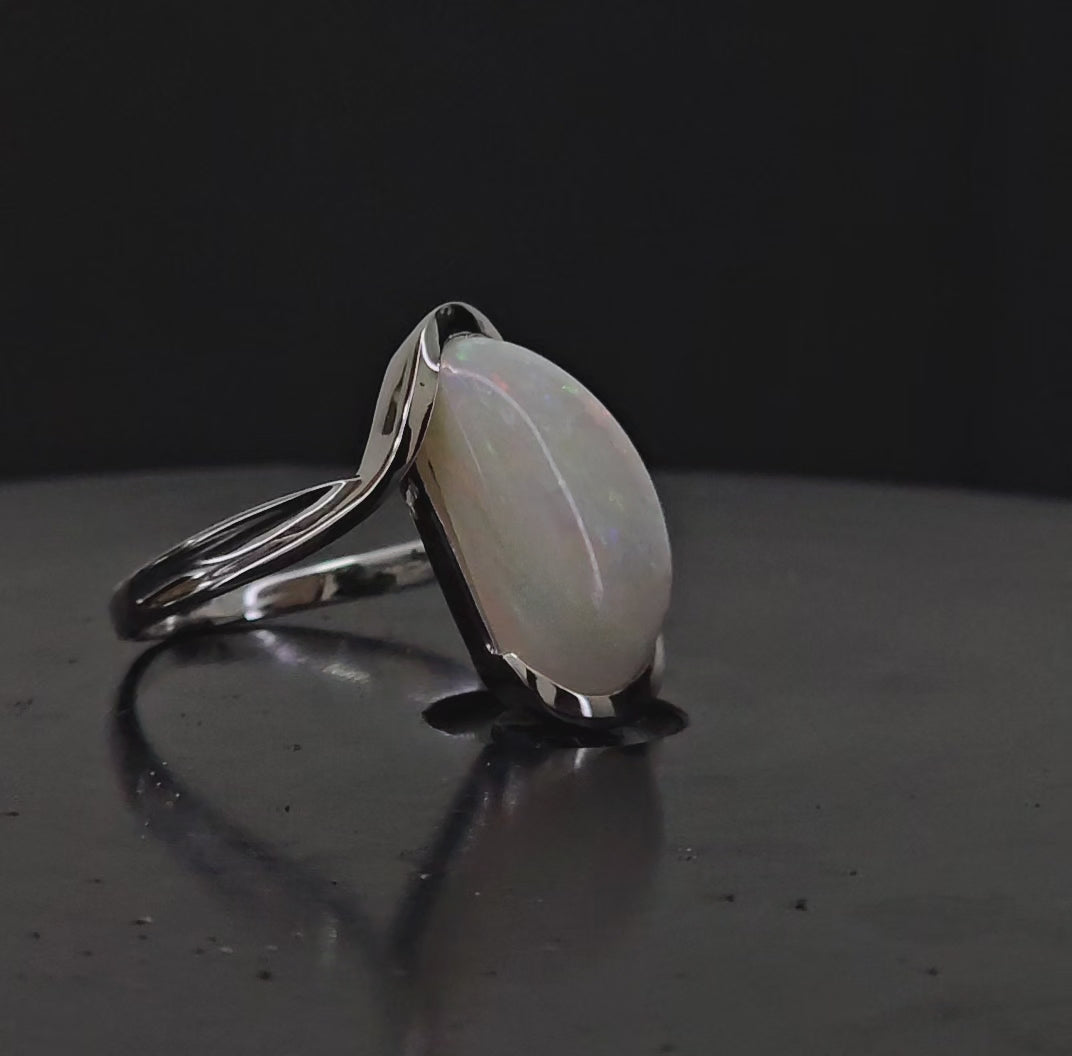 Video showing large white opal set in silver ring rotated 180 degrees.