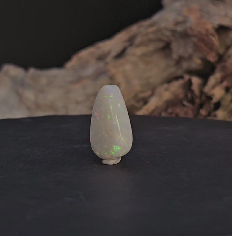 Video showing the solid natural white opal rotate to reveal all sides of the opal.