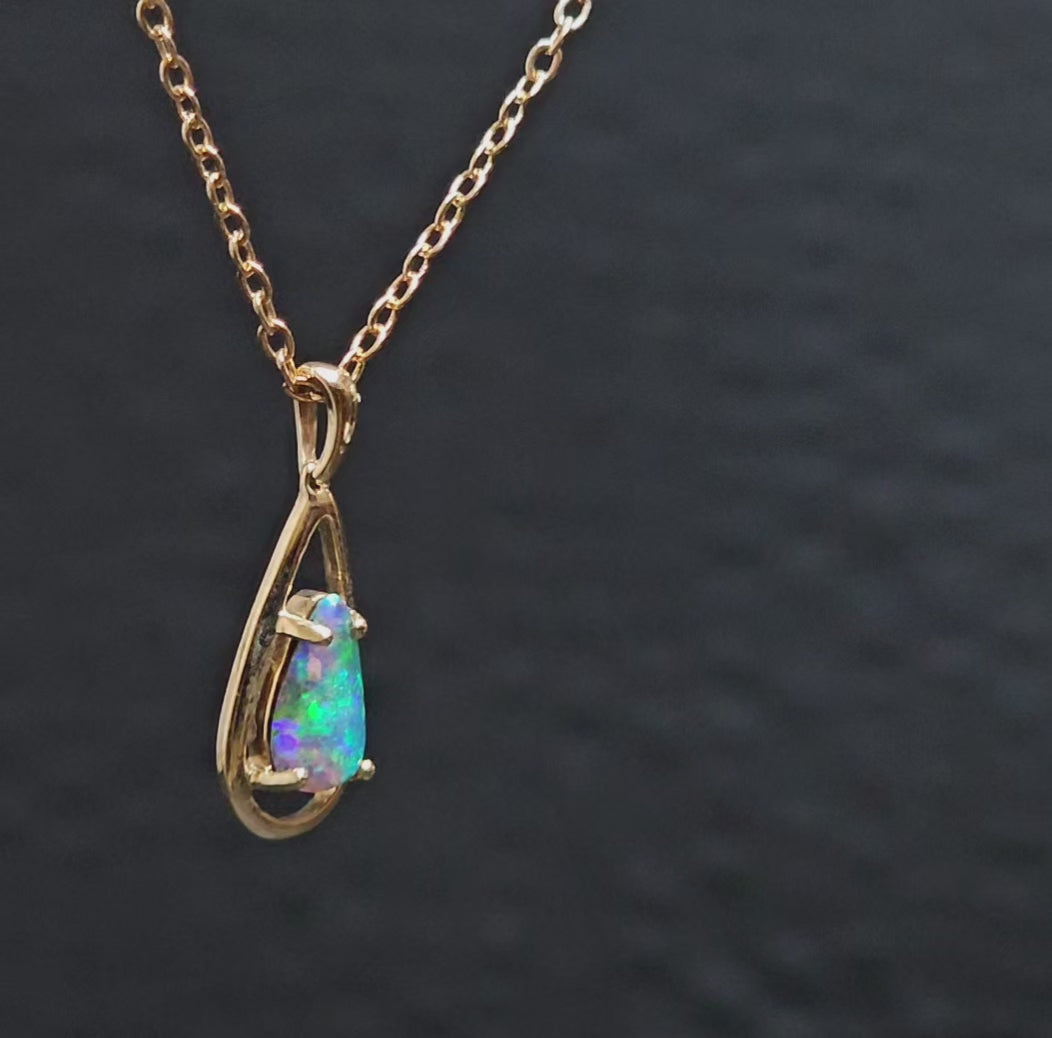 Video showing opal and gold pendant rotate to show both sides of the piece of jewellery.