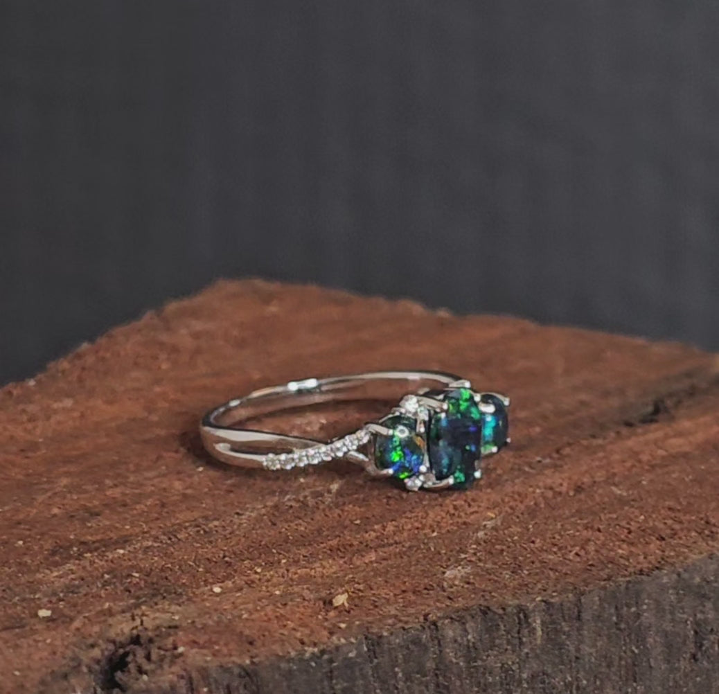 Video showing the tri-black opal and diamond white gold ring rotate 180 degrees.