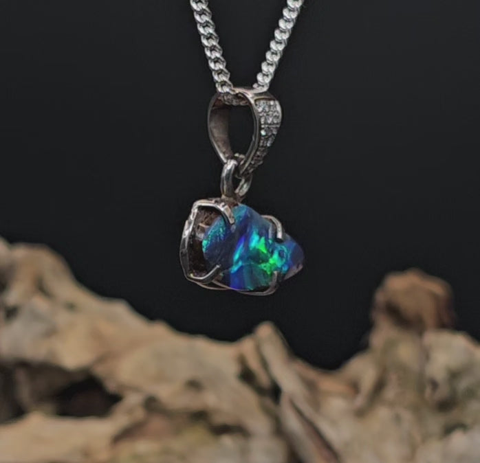 Video showing the white gold and opal pendant rotate 180 degrees.