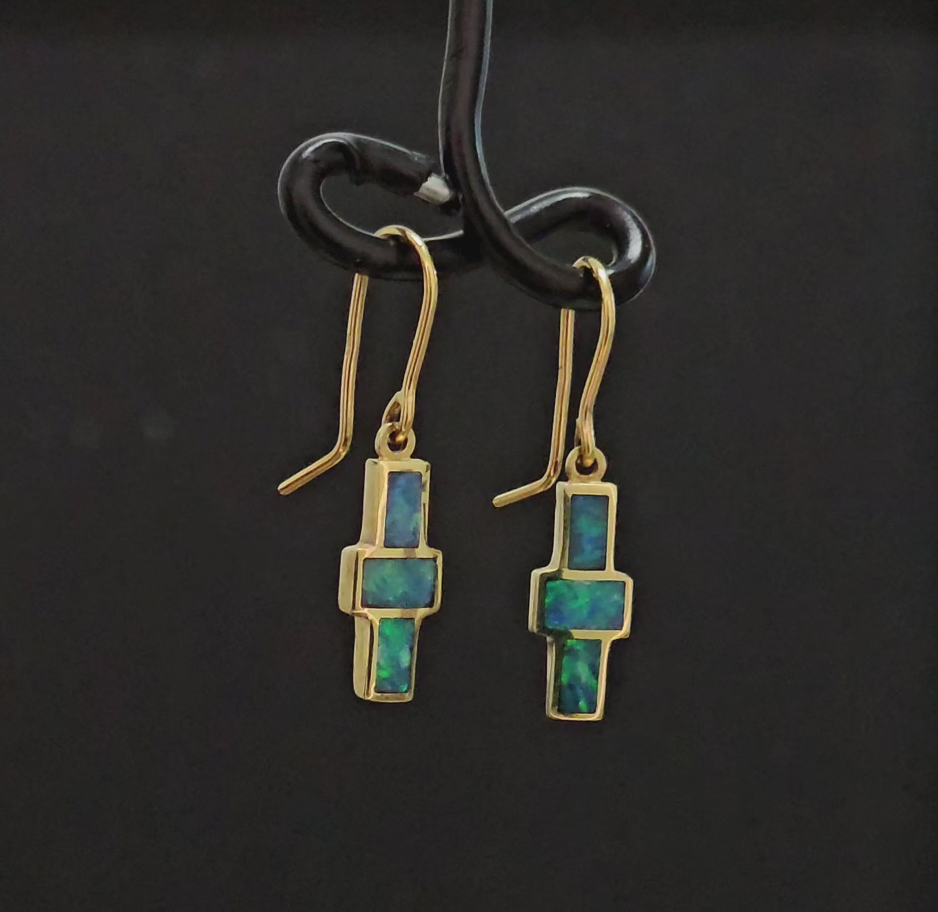 3 dark green opals set in each yellow gold earring. Hooks are in a cross design. Back is enclosed.