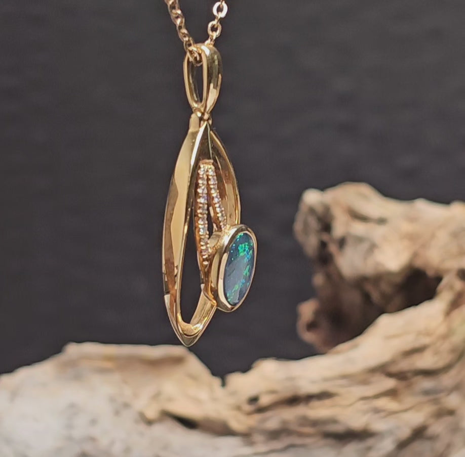 Video showing the black opal and diamonds in a gold necklace rotate 180 degrees.