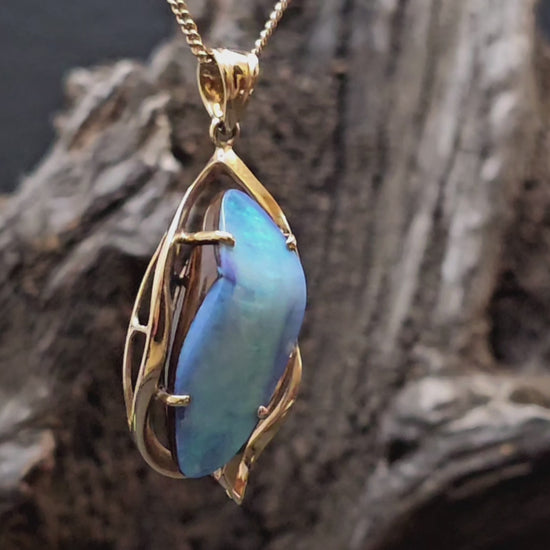 Large boulder opal set in yellow gold pendant shown rotating in this video.