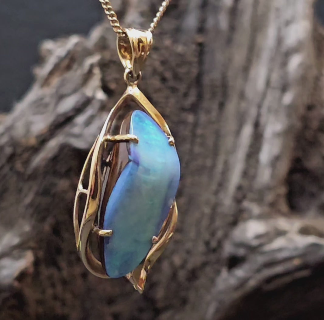 Large boulder opal set in yellow gold pendant shown rotating in this video.