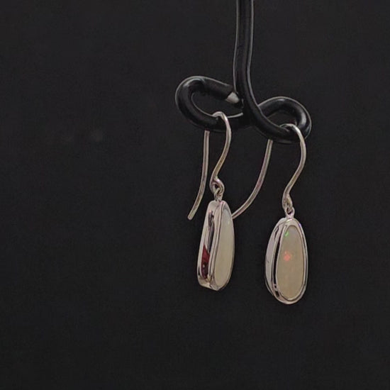 Light opal besel set in silver shepherd hook earrings.