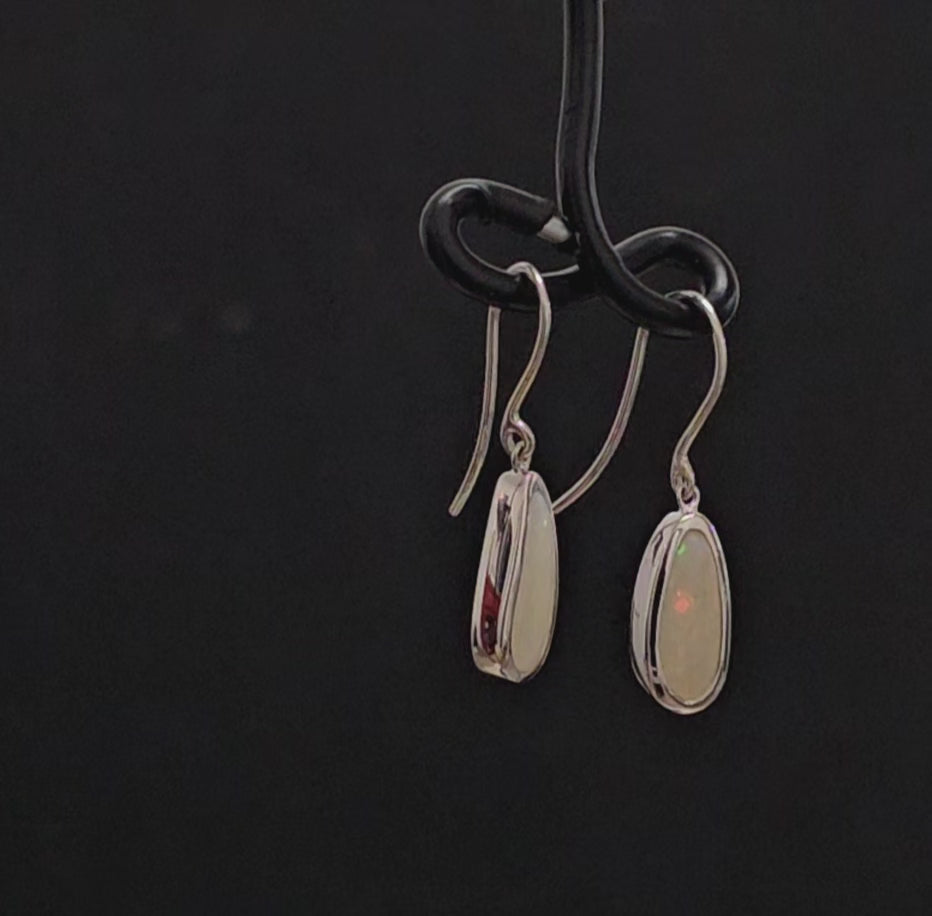 Light opal besel set in silver shepherd hook earrings.