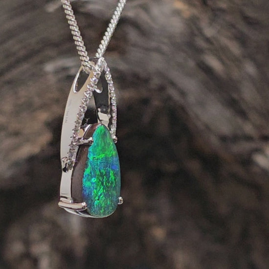 Video showing white gold necklace with diamonds and a dark blue and green boulder opal spin.