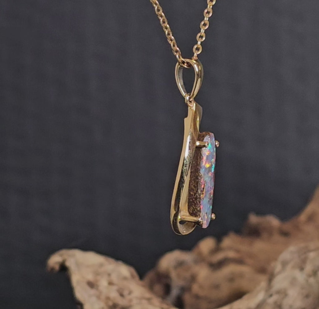 Video showing the yellow gold and boulder opal necklace rotate 180 degrees.